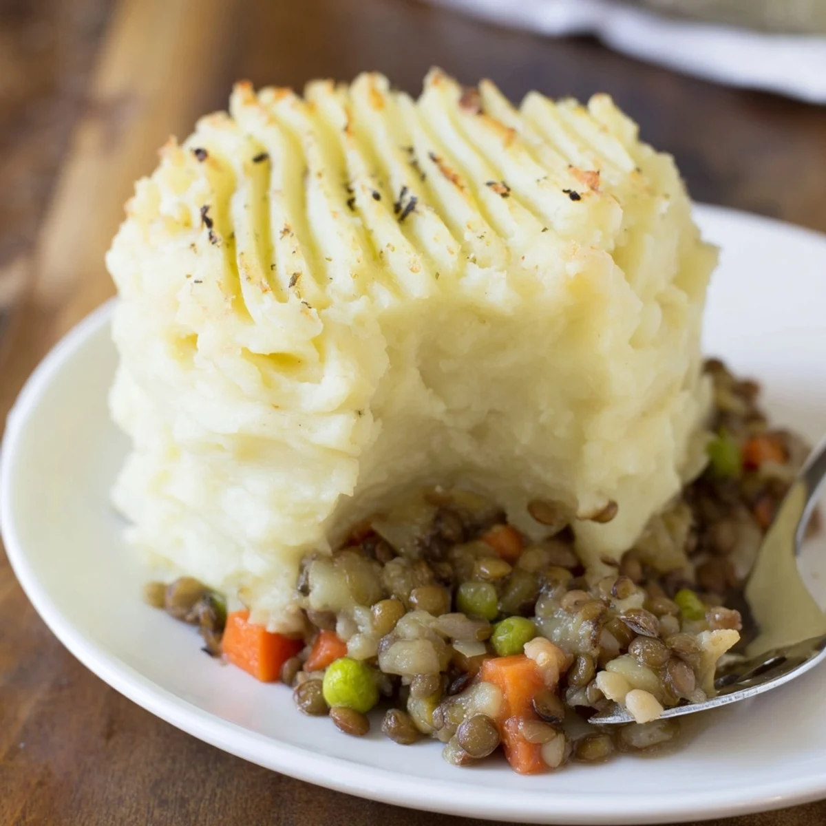 Warm, inviting image of a serving of Hearty Lentil Shepherd's Pie, perfect for a cozy, vegetarian dinner.
