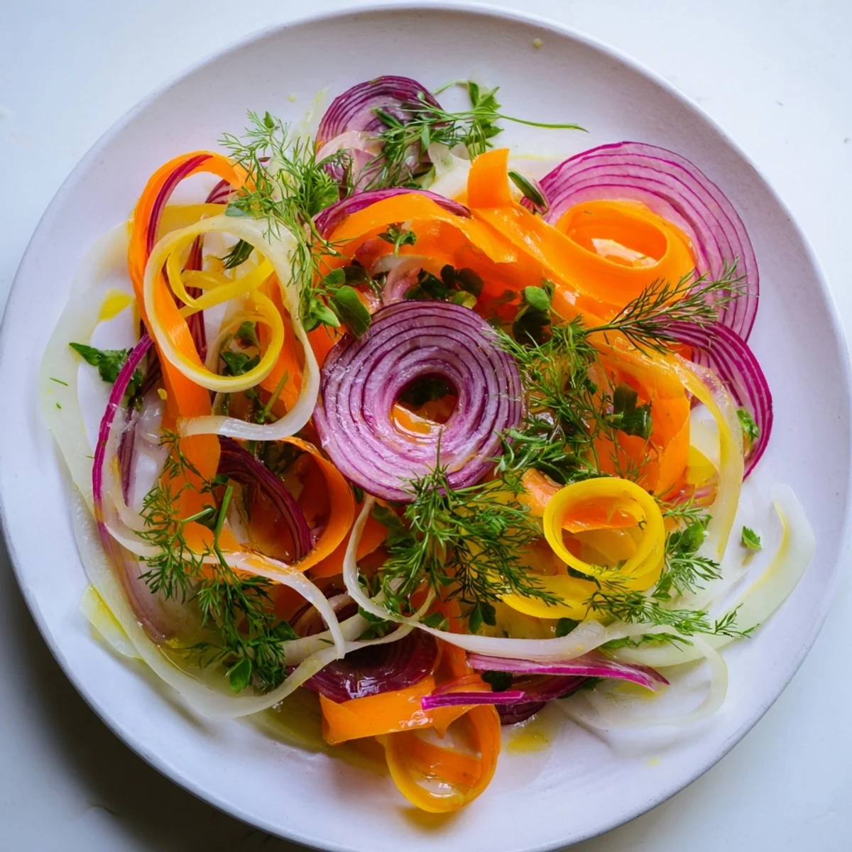 This The Spinning Top salad showcases wispy vegetables and herbs, ready to be drizzled with a light lemon dressing.