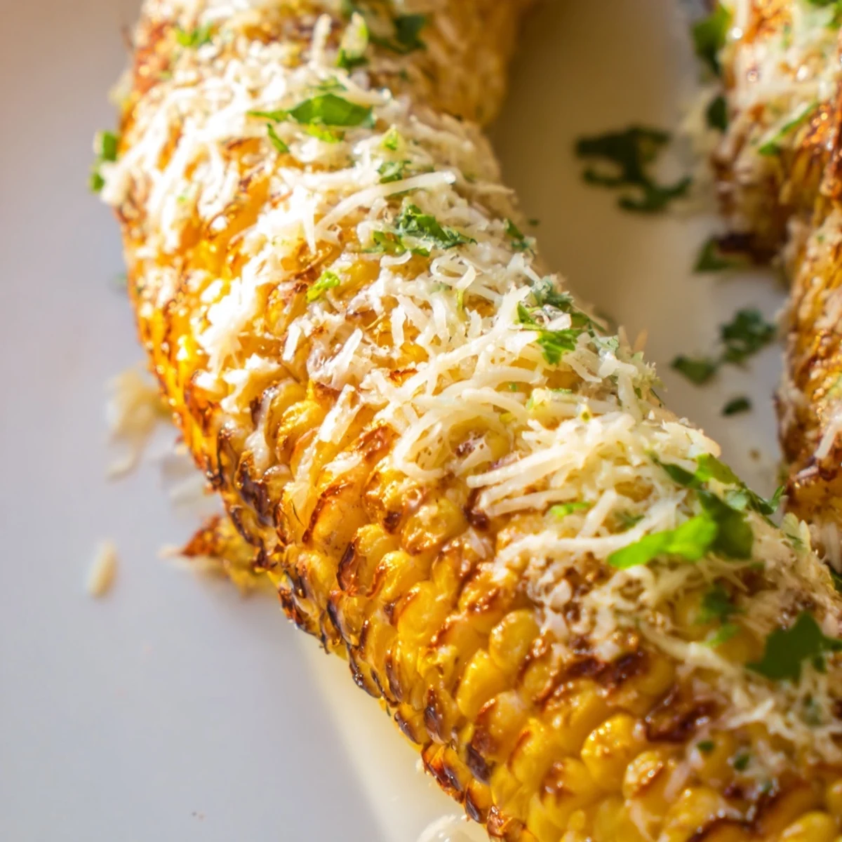 Crispy, oven-baked corn ribs seasoned with smoked paprika and cumin, topped with bubbling cheese and fresh cilantro for serving.