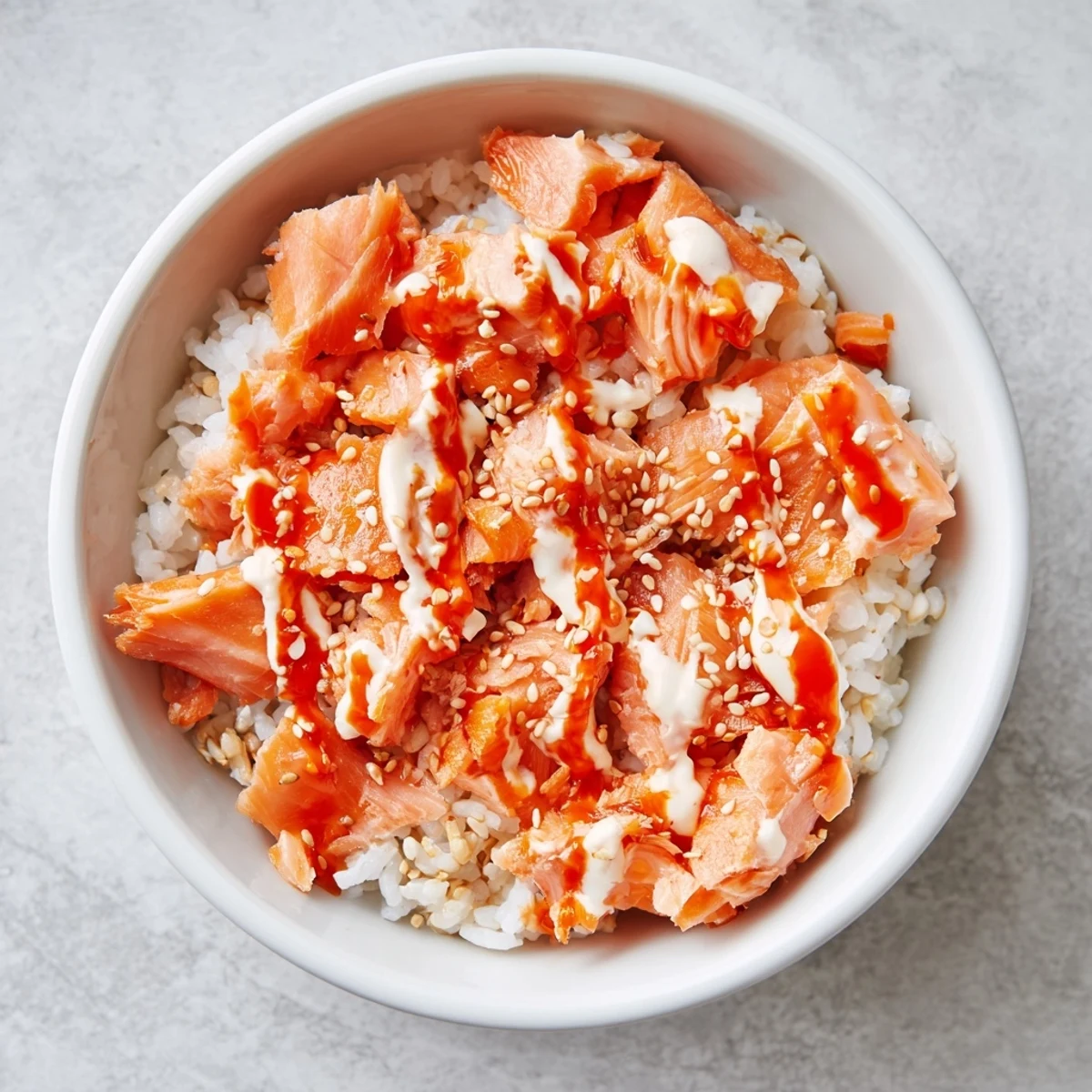 Viral-inspired Emily Mariko salmon rice bowl featuring fluffy rice mixed with salmon, avocado, spicy mayo, and nori sheets for a quick lunch or dinner.