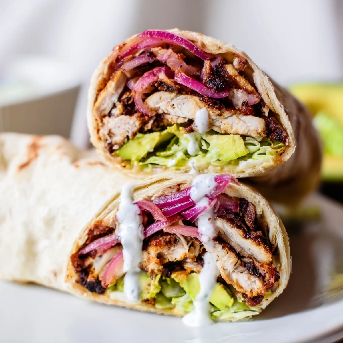 Assembled Smoky Chipotle Chicken Wrap ready to serve, featuring creamy Greek yogurt sauce and vibrant red onion.