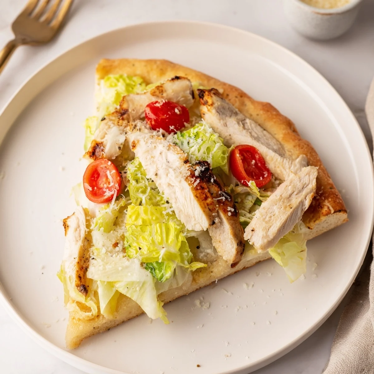 Golden-brown Chicken Caesar Flatbread topped with grilled chicken, crisp romaine, Caesar dressing, and parmesan, served on a wooden board.