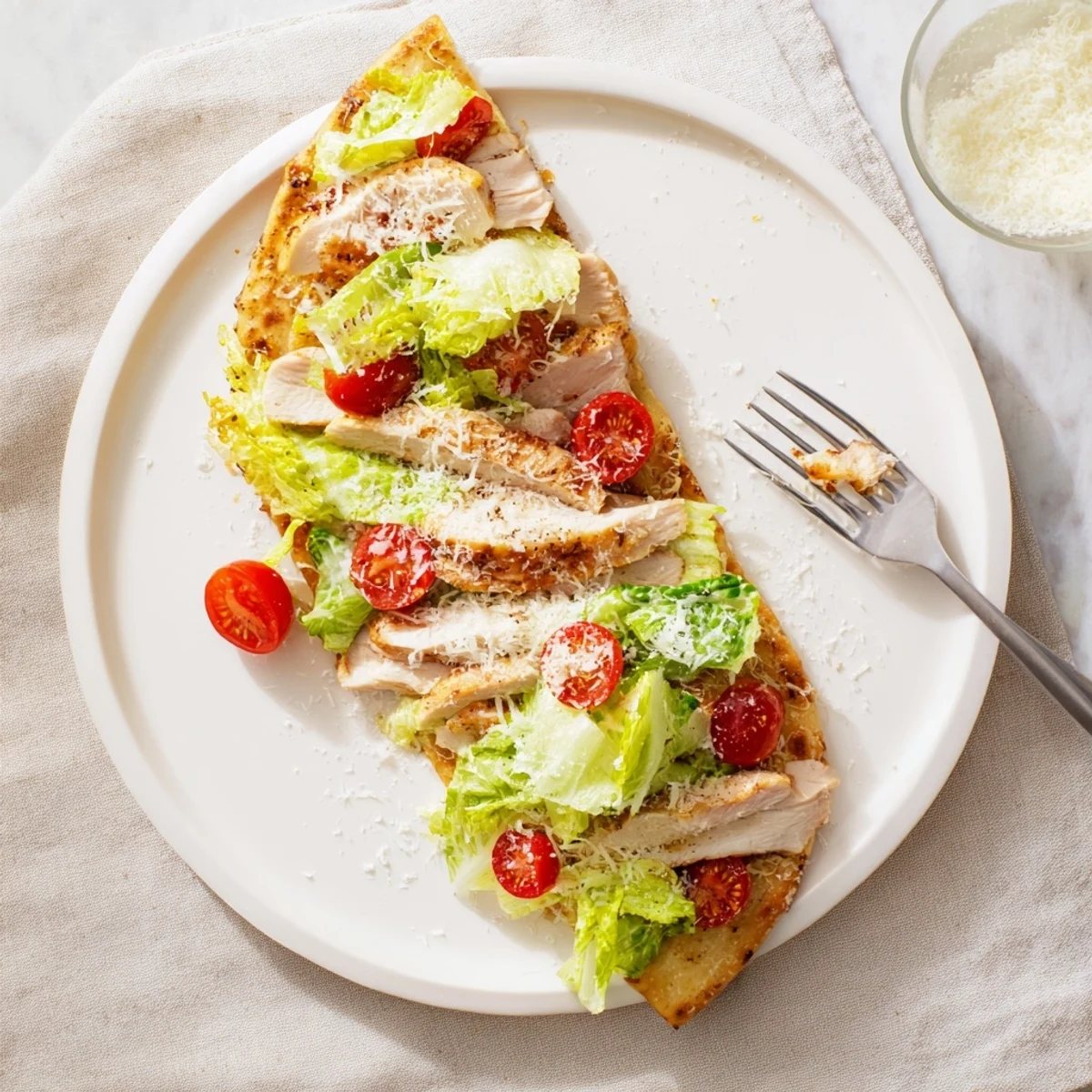Rustic Chicken Caesar Flatbread with sliced grilled chicken, romaine, creamy Caesar, and cherry tomatoes on a golden, crisp flatbread crust.