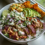 Sliced chicken and bright street corn top a bed of rice in this gluten-free Street Corn Chicken Rice Bowl.