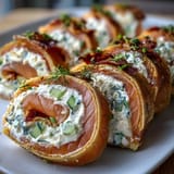 Creamy dill-infused cream cheese, smoked salmon, and fresh cucumber rolled in flour tortillas, sliced into bite-sized pinwheels for elegant snacking.