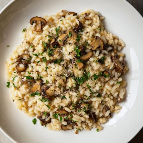 Golden risotto, a creamy Italian delight, topped with fresh parsley; savor this creamy Stove-Top Creamy Risotto!