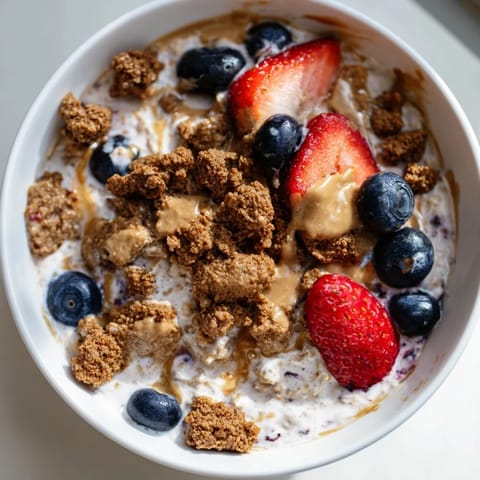 Vibrant image shows layered Overnight Oats Gourmet Makeover topped with berries and crispy cookie crumbles.