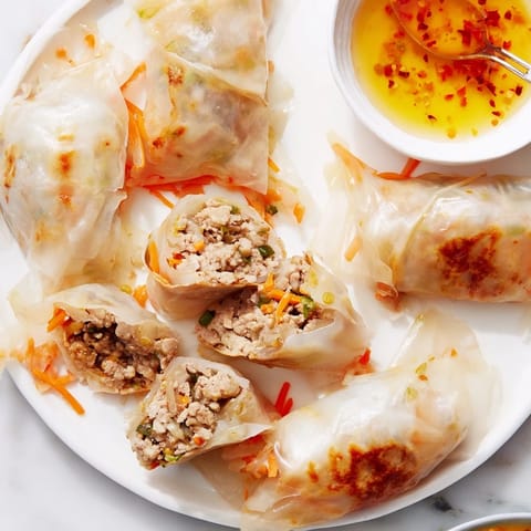 Close-up of Crispy Rice Paper Dumplings with a crunchy golden exterior and fresh, colorful vegetable filling on a plate.