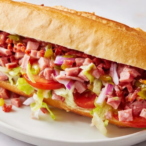 This hearty chopped Italian grinder sandwich features golden toasted bread filled with savory Italian meats, melted provolone, and crunchy vegetables.  