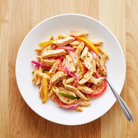 Fajita Chicken Pasta Skillet features tender spiced chicken strips, colorful bell peppers, onions, and melted cheddar.